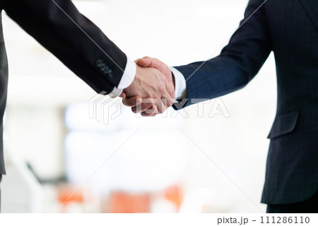 握手をするスーツ姿のビジネスマン　顔なし 111286110