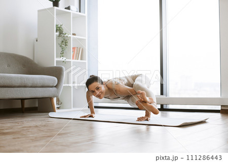 Strong woman doing power yoga during training indoors. Strong woman doing power yoga during training indoors. 111286443