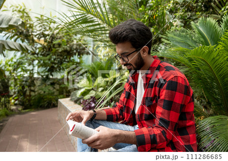 Young man reading a book and looking involved 111286685