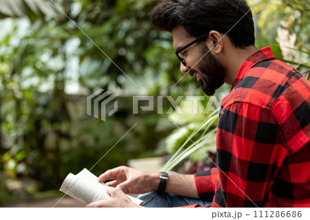 Young man reading a book and looking involved Young man reading a book and looking involved 111286686