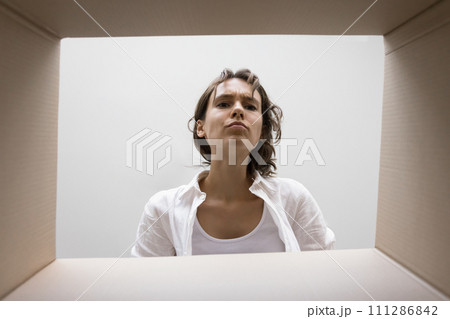 Curious focused young woman checking parcel from Internet ecommerce store 111286842