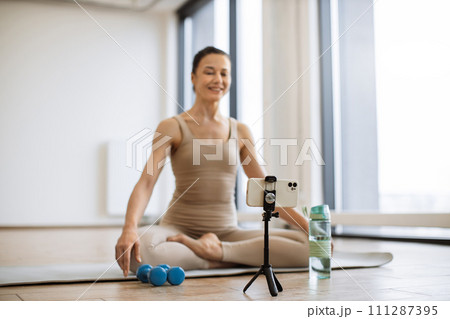 Blogger shooting video content on smartphone for own followers about meditation. Blogger shooting video content on smartphone for own followers about meditation. 111287395
