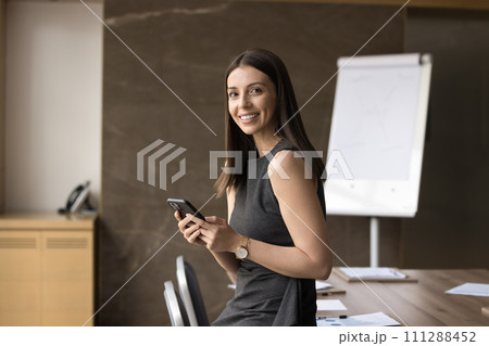 Happy beautiful Latin business leader woman holding smartphone Happy beautiful Latin business leader woman holding smartphone 111288452
