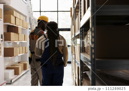 African american distribution supervisor and warehouse assistant searching parcel in storage room. Storehouse worker helping logistic manager doing inventory in storehouse African american distribution supervisor and warehouse assistant searching parcel in storage room. Storehouse worker helping logistic manager doing inventory in storehouse 111289025