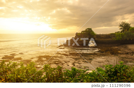 Beautiful sunset view of Pura Batu Bolong an iconic Hinduism sea temple nearly Tanah Lot temple in Bali island of Indonesia. 111290396