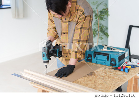 家でDIYをする中年男性 111291116