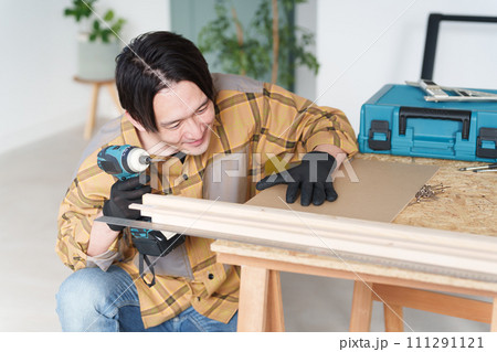 家でDIYをする中年男性 111291121