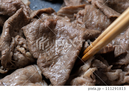 牛肉(ウデ薄切り)をフライパンで炒める調理シーン。 111291813