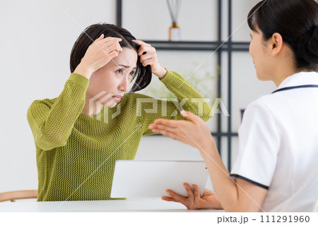 生え際を相談するミドルの女性  生え際を相談するミドルの女性  111291960