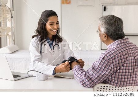 Happy beautiful doctor woman measuring blood pressure of senior patient Happy beautiful doctor woman measuring blood pressure of senior patient 111292699