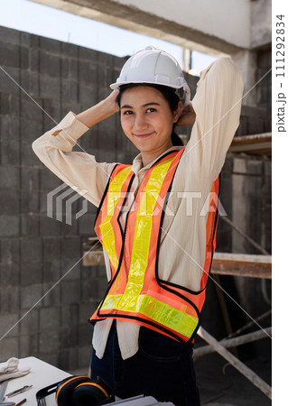 Female construction engineer. Architect with a blueprint at a construction site Female construction engineer. Architect with a blueprint at a construction site 111292834