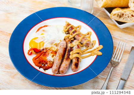 Healthy breakfast of scrambled eggs with sausages Healthy breakfast of scrambled eggs with sausages 111294348