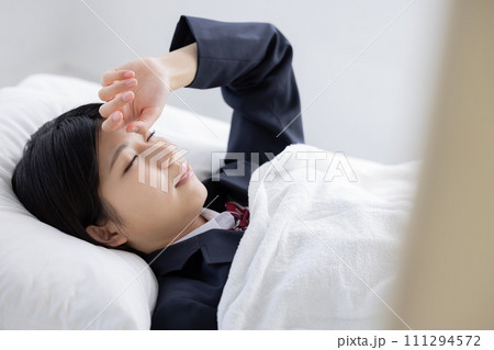 保健室のベッドで休む女子高生　 111294572