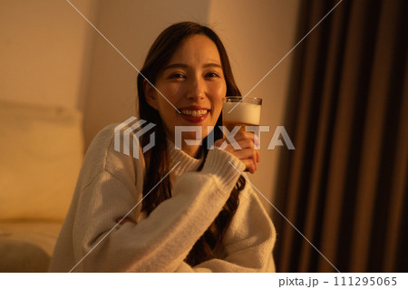 夜に部屋でビールを飲む女性 111295065