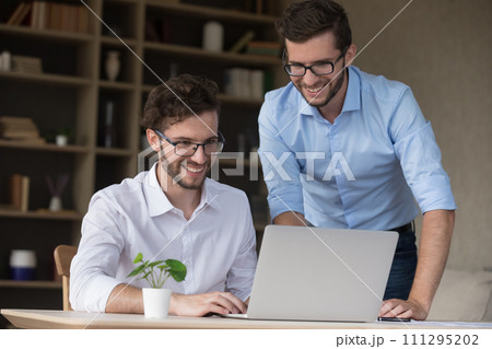 Two twins brothers enjoy creative workflow online 111295202