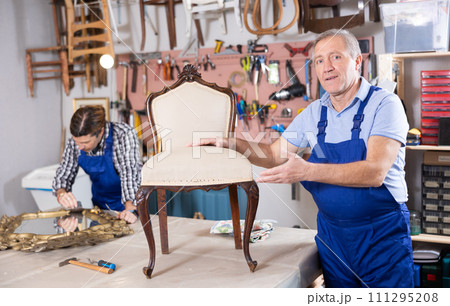 Master restoration worker dressed in overalls poses in working atmosphere of his workshop 111295208