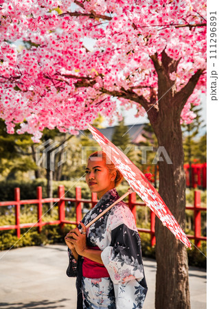 Asian girl in kimono and umbrella in Japanese theme park Hinoki Land in Chai Prakan District, Chiang Asian girl in kimono and umbrella in Japanese theme park Hinoki Land in Chai Prakan District, Chiang 111296891