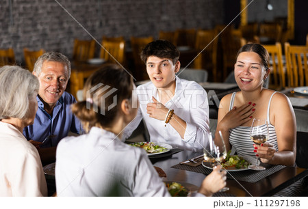Large family, company of spouses in restaurant, eat, celebrate important event, communicate. Large family, company of spouses in restaurant, eat, celebrate important event, communicate. 111297198