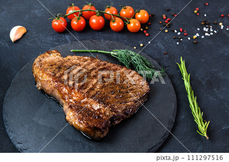 Grilled beef steak ribeye rare on on dark background Grilled beef steak ribeye rare on on dark background 111297516
