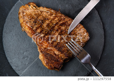 Grilled beef steak ribeye rare on on dark background top view 111297558