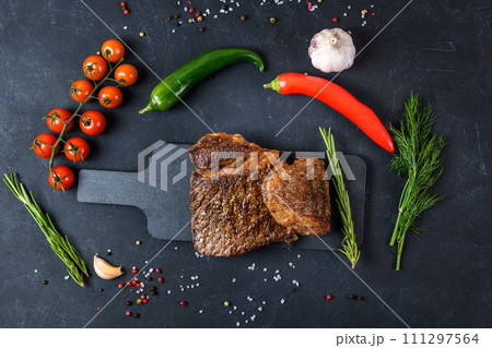 Grilled beef steak ribeye rare on on dark background top view 111297564