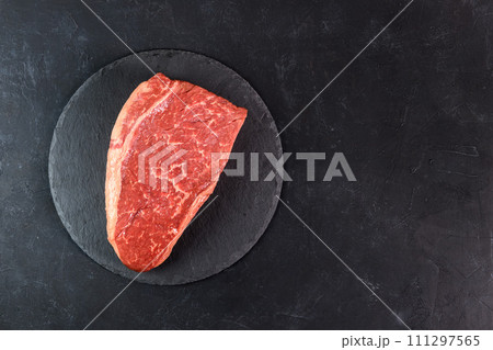Raw fresh marbled meat on dark background top view Raw fresh marbled meat on dark background top view 111297565