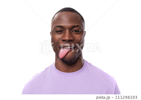 young excited american man with short haircut wearing lilac t-shirt makes a grimace young excited american man with short haircut wearing lilac t-shirt makes a grimace 111298103