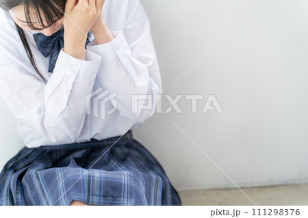 教室の隅でうずくまり怖がる女子高生・高校生・中学生（いじめ・暴力・DV・殴られる・毒親・精神病） 111298376