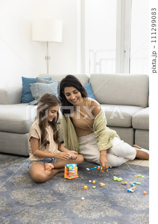 Happy young mother and cute daughter child constructing toy tower Happy young mother and cute daughter child constructing toy tower 111299083