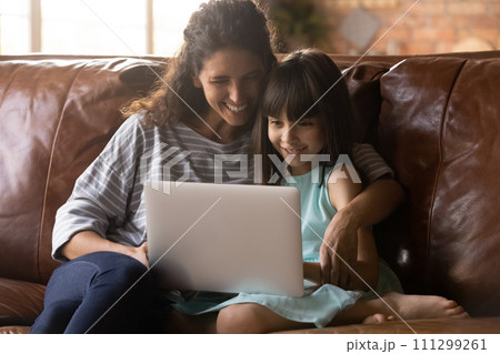 Young nanny and little girl friends use laptop at home Young nanny and little girl friends use laptop at home 111299261