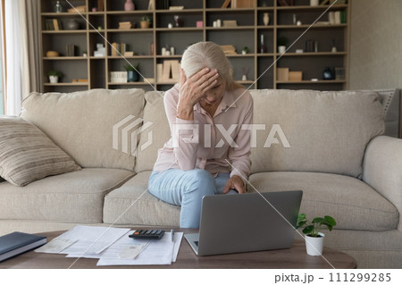 Upset senior woman check domestic expenditures feels stressed Upset senior woman check domestic expenditures feels stressed 111299285