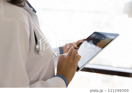 Hands close up of female practitioner holding digital tablet Hands close up of female practitioner holding digital tablet 111299300