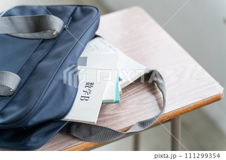 教室にある机の上に置かれた教科書とスクールバッグ 111299354