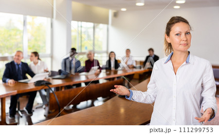 Portrait of positive woman secretary gesturing in meeting room Portrait of positive woman secretary gesturing in meeting room 111299753
