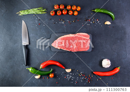 Raw fresh marbled meat and seasonings on dark background top view Raw fresh marbled meat and seasonings on dark background top view 111300763