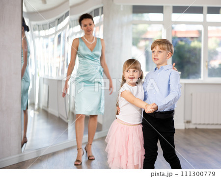 Boy and girl in pair train to dance contemporary vigorous waltz during classes. 111300779