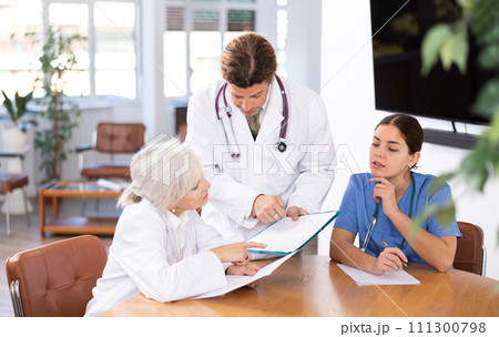 Professional physician discussing diagnosis of patients with colleagues Professional physician discussing diagnosis of patients with colleagues 111300798