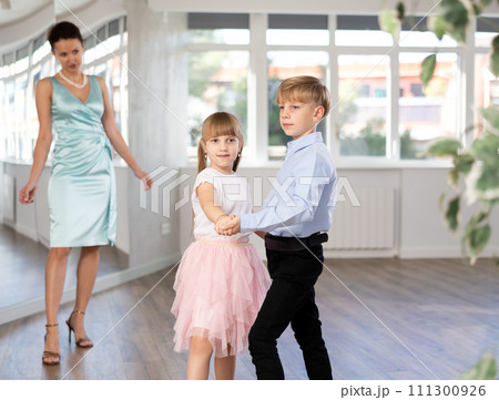 Tween dancers, girl and boy practicing waltz in dance studio Tween dancers, girl and boy practicing waltz in dance studio 111300926