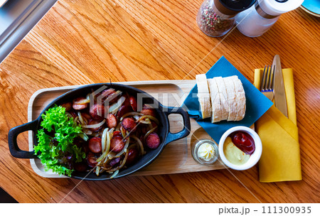 Fried sausages with onions Fried sausages with onions 111300935