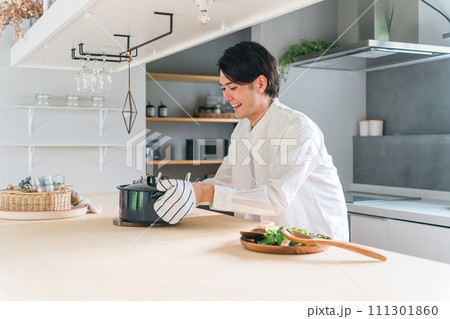 キッチンで料理をする鍋を持った若い男性（料理教室・おもてなし・手料理・料理男子） 111301860