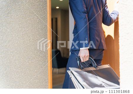 自宅の玄関を開けるスーツの男性ビジネスマン(顔なし) 自宅の玄関を開けるスーツの男性ビジネスマン(顔なし) 111301868