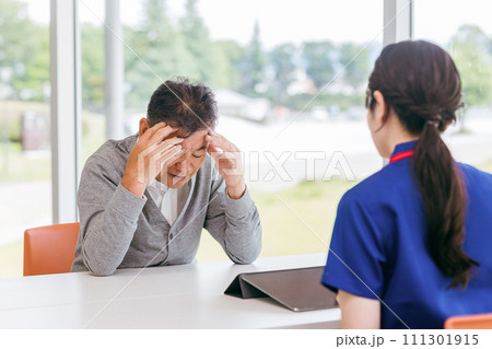体調不良・頭痛を相談する高齢者男性（疲労・眼精疲労・高血圧） 111301915
