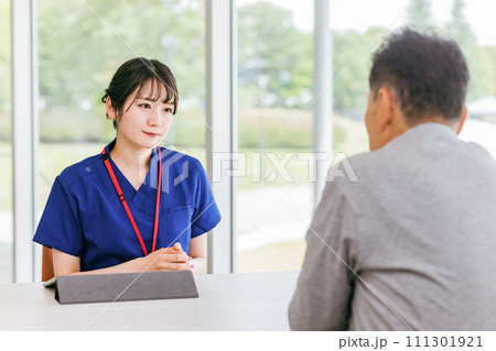 カウンセリング・問診・診察をするカウンセラー・理学療法士の女性（リハビリ・介護・ケアプラン） 111301921