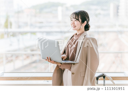駅・ターミナルでパソコンを使う女性・ビジネスウーマン 111301951