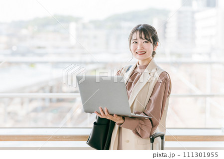 駅・ターミナルでパソコンを使う女性・ビジネスウーマン 111301955