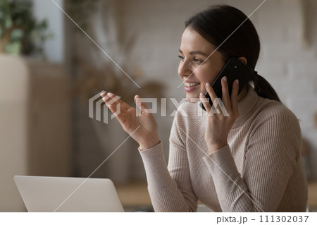 Pretty woman having pleasant conversation on cellphone at home 111302037