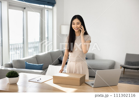 Happy young Asian consumer woman getting purchase from Internet store Happy young Asian consumer woman getting purchase from Internet store 111302116