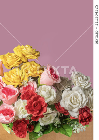 Bouquet of colorful artificial flowers in paper box on pink background with copy space. Bouquet of colorful artificial flowers in paper box on pink background with copy space. 111304325