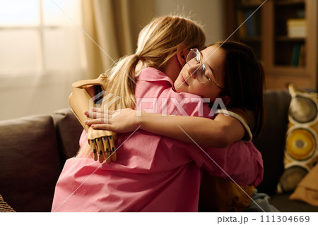 Mother and child embracing on couch 111304669