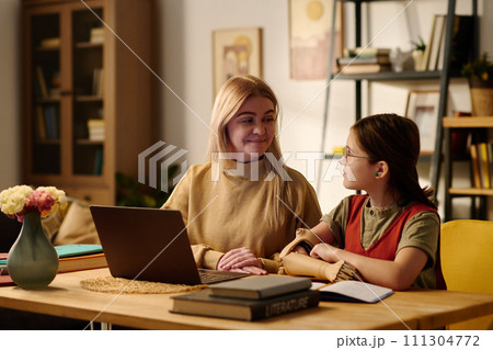 Clever amputee girl looking at tutor 111304772